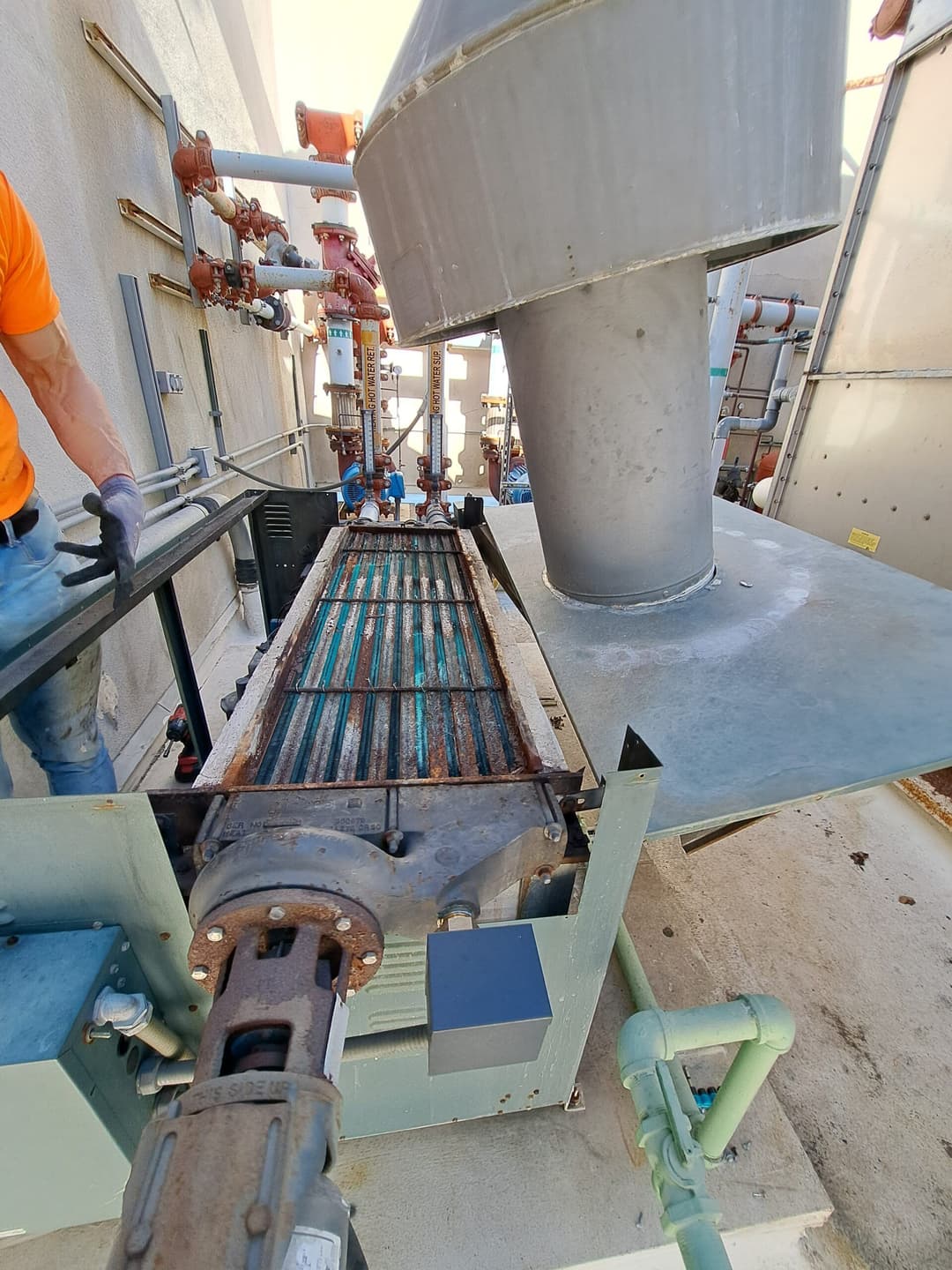 Industrial equipment with conveyor and ventilation system in a maintenance setting.