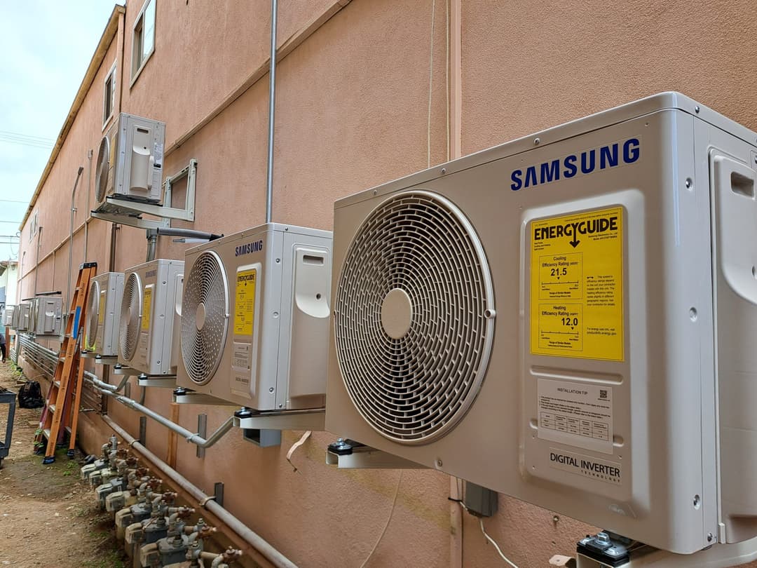 Samsung air conditioning units mounted on a building's exterior, showcasing energy efficiency ratings.