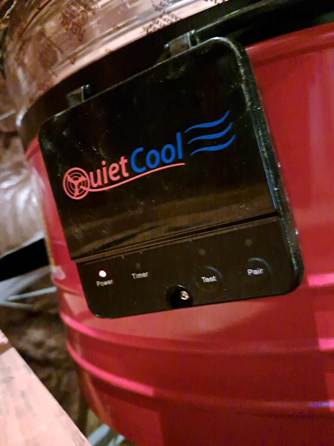 QuietCool fan control panel on a red cooling unit with power and timer settings.