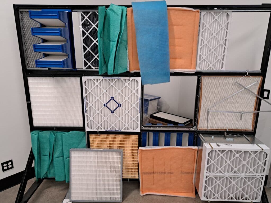 Display of various air filters in a structured arrangement on a wall.